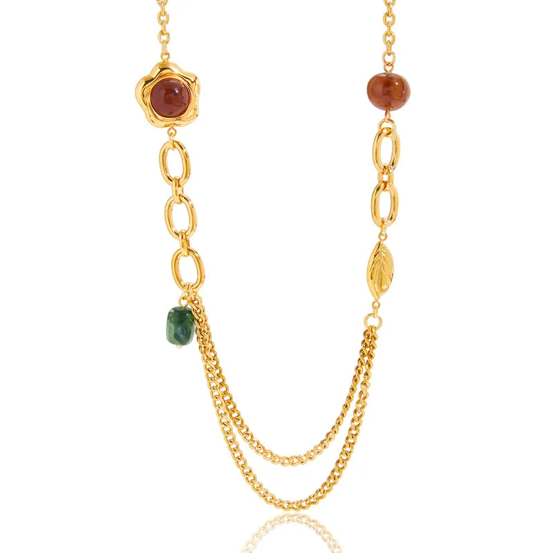 Gold necklace with gemstone beads on a white background