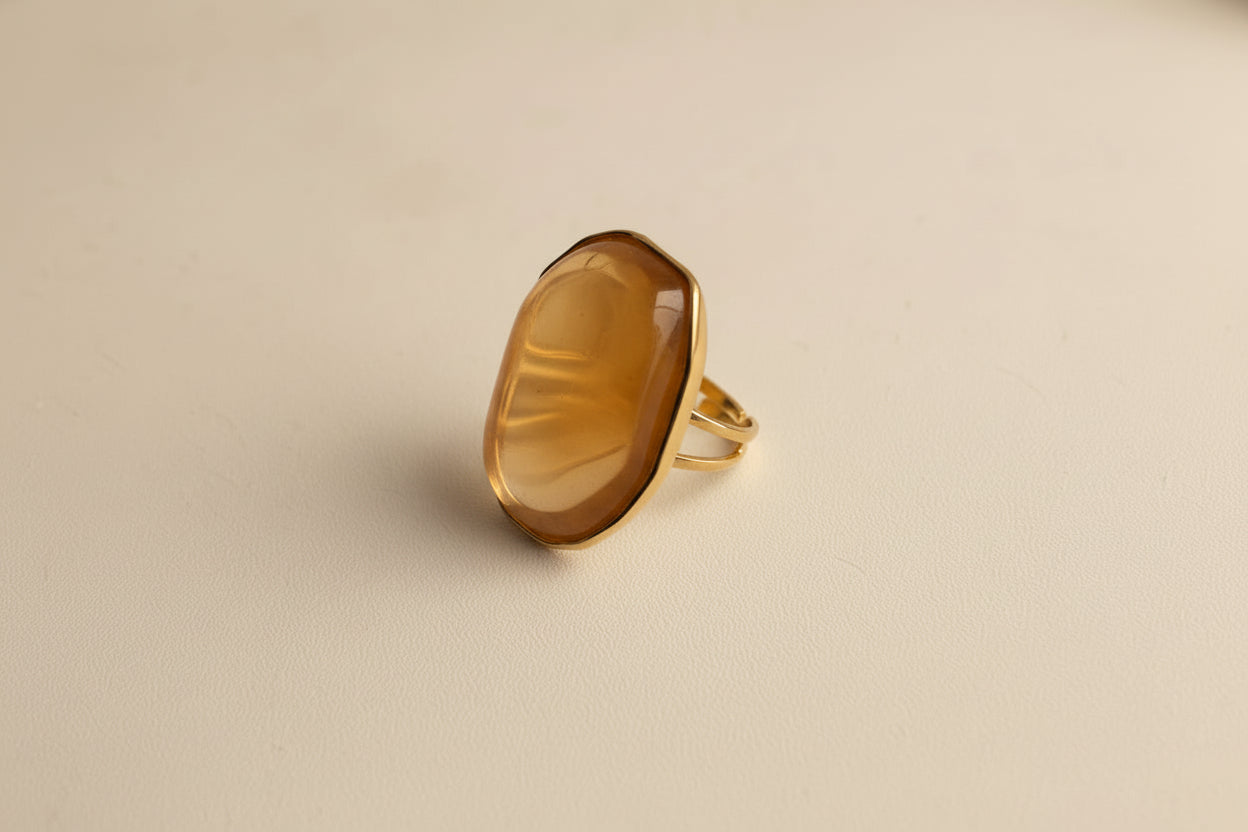 Gold ring with a large brown gemstone on a white background