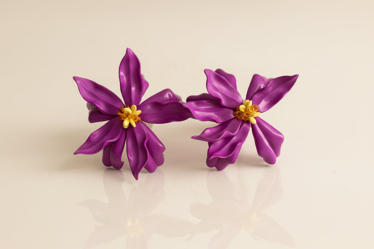 Pair of purple flower-shaped earrings on a light gray background